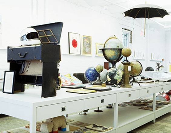 Photograph of a large central table and retail display cases for Partners & Spade's original downtown office & storefront. Design: Partners & Spade, Rogers Marvel Architects